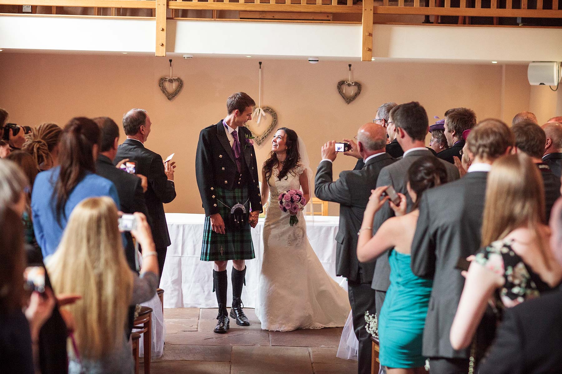 Unobtrusive creative wedding photography story of the beautiful ceremony in the barn at The Ashes in Endon by Leek Documentary Wedding Photographer Stuart James