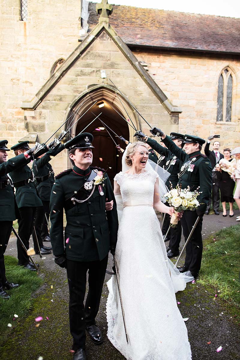 Fabulous guard of honour exit from the church at All Saints Church in Sandon by Staffordshire Documentary Wedding Photographer Stuart James