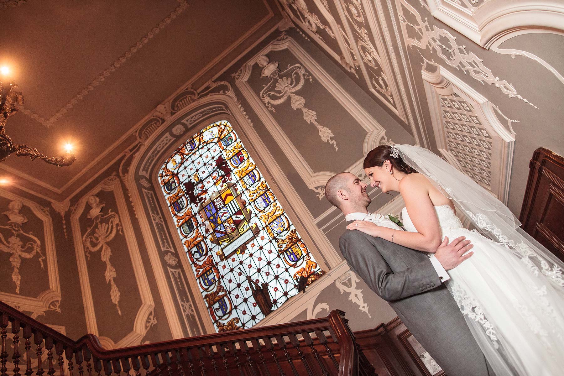 Elegant photographs on staircase at Chillington Hall in Brewood by Reportage Wedding Photographer Stuart James
