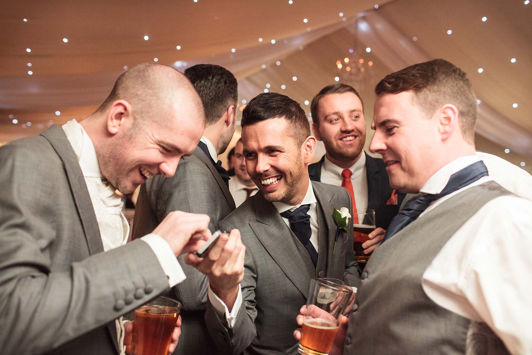 Great photographs of guests relaxing during evening reception in marquee at Chillington Hall in Brewood by Reportage Wedding Photographer Stuart James