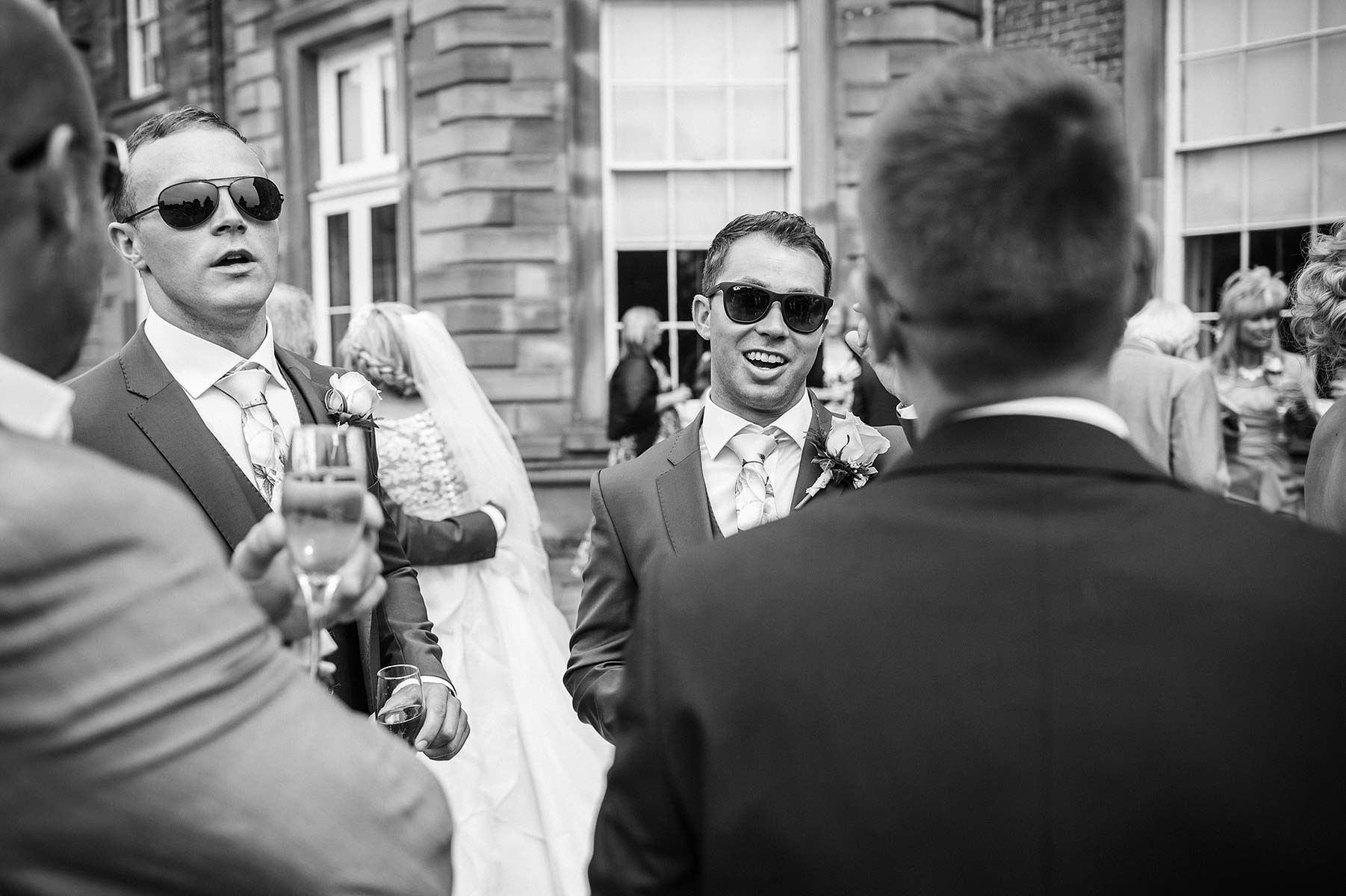 Guests enjoying drinks reception on terrace at Weston Park in Staffordshire by Documentary Wedding Photographer Stuart James